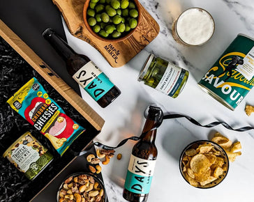 https://cdn.shopify.com/s/files/1/0507/4986/6152/files/non-alcoholic-lager-and-nibbles-gift-set-IMP2301-02.webp?v=1697105227&width=364