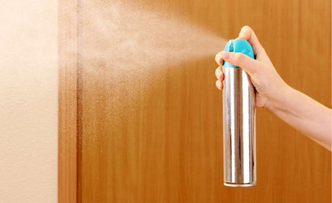 spraying an air freshener 