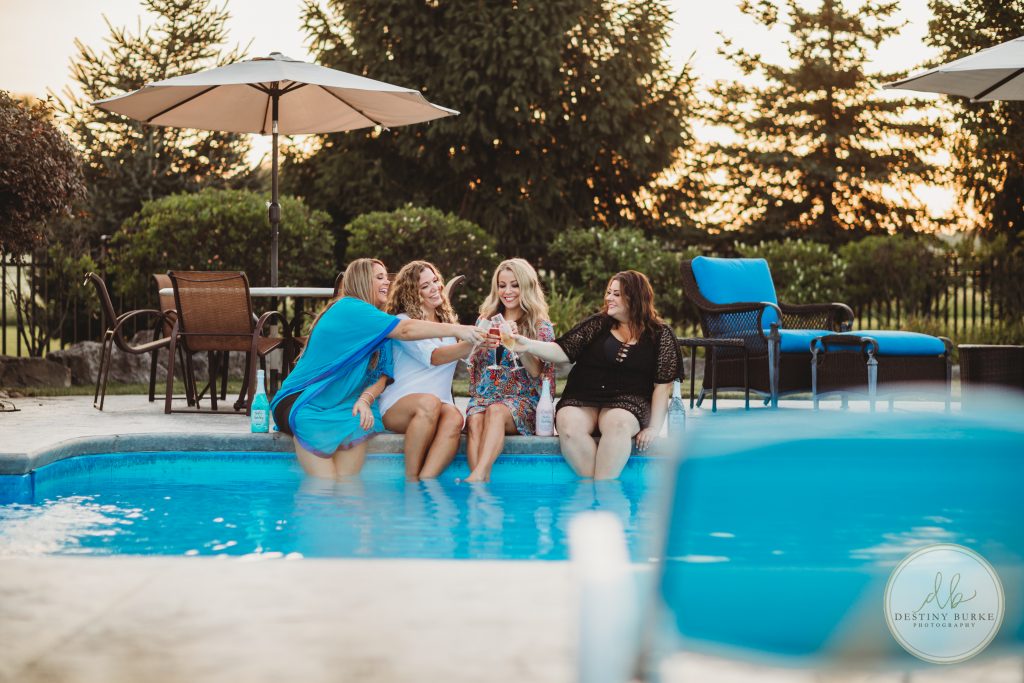 Four women sitting by a pool drinking Bestie Bubbly wine making memories, photo by DestinyBurke photography