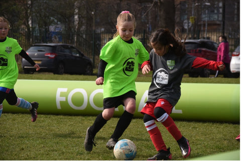 2 girls playing football in inflatable arena