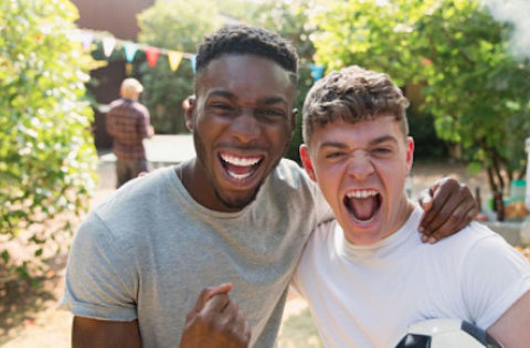 2 teenage boys smiling and cheering 