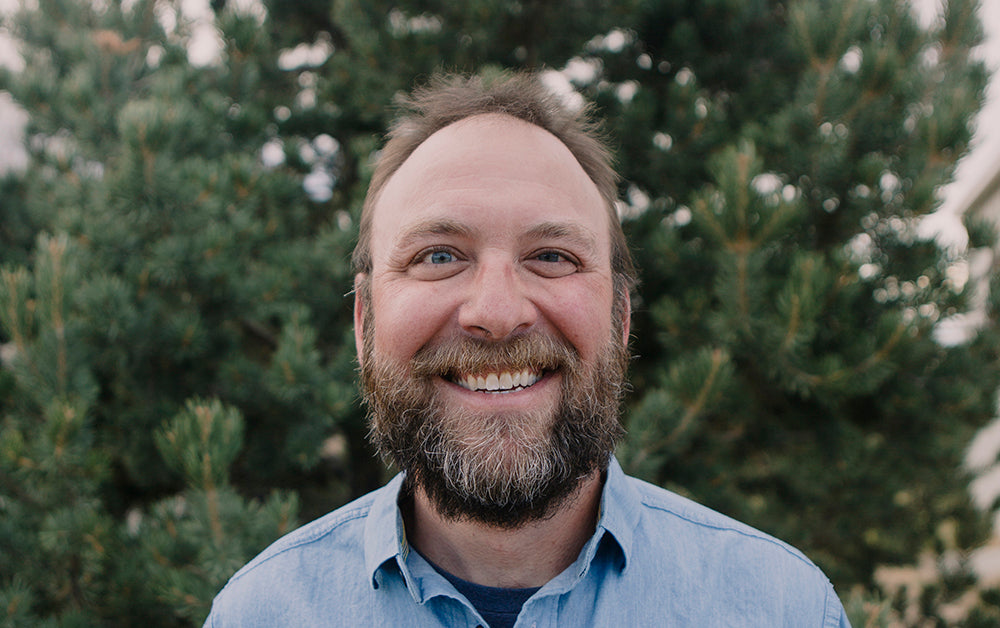 Man smiling in denim shirt