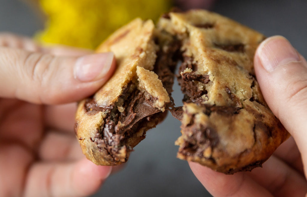 Close up breaking a chocolate chip cookie in half