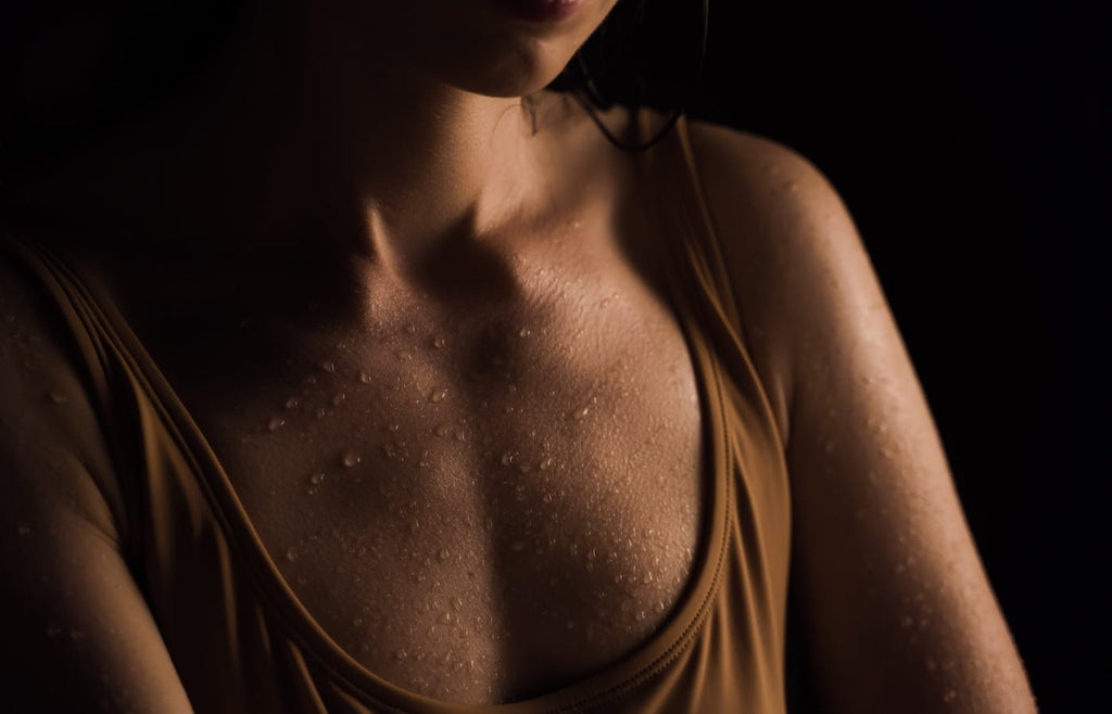 Woman with beads of sweat on chest