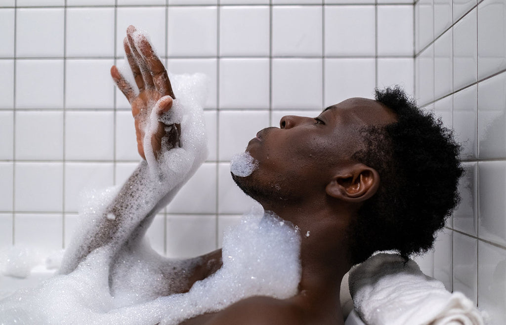 Man blowing bubbles in the bathtub