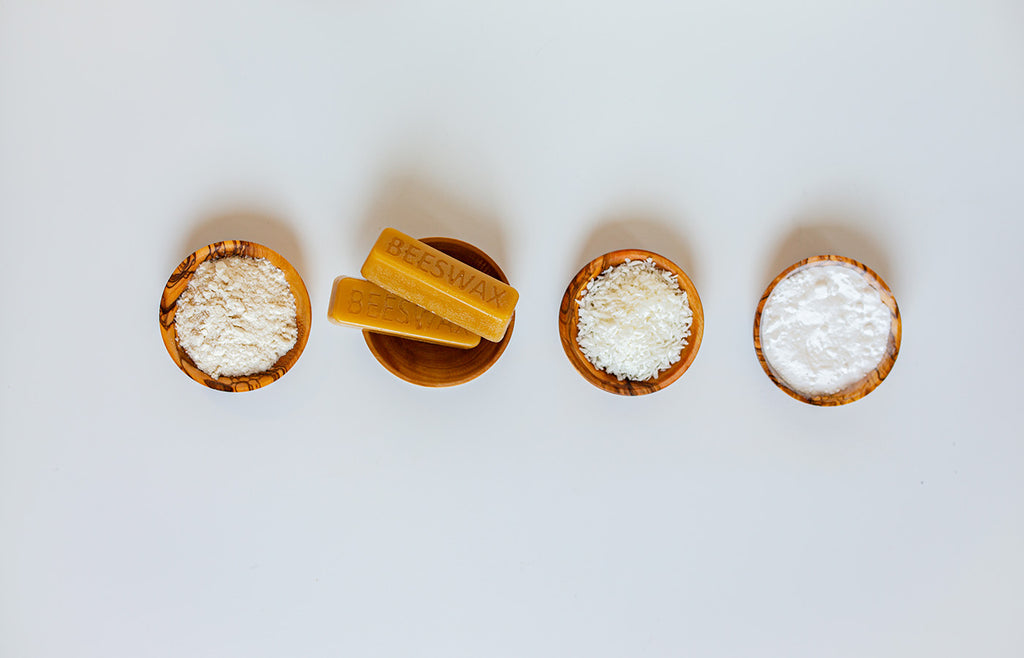 Four natural deodorant ingredients lined up in small wooden bowls