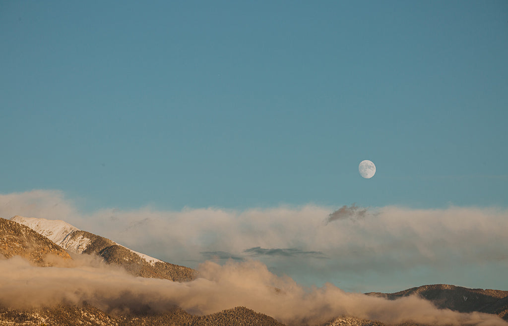 Taos mountains with moon in blue sky