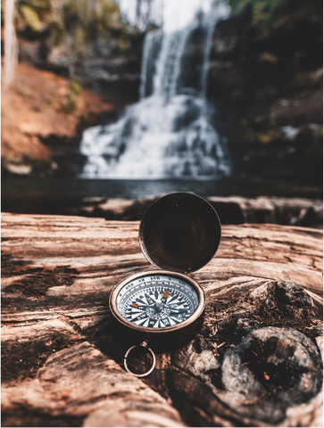 Kompass, Wasserfall im Hintergrund