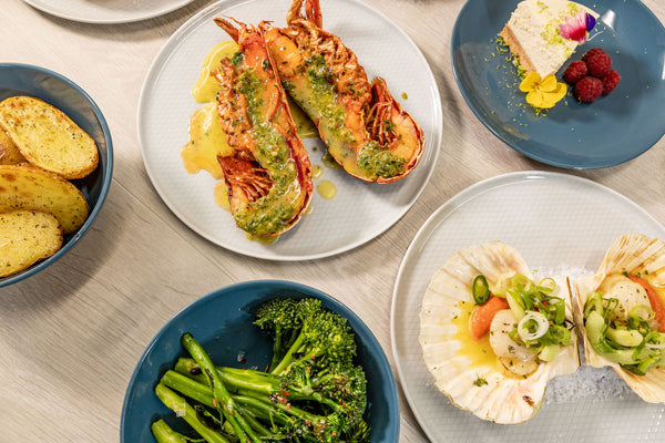 lobster, broccoli, scallops and vegetables on a dining table