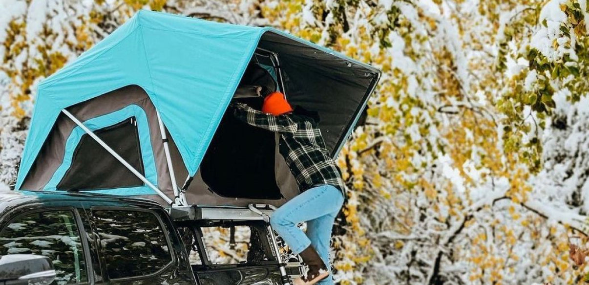 Man entering Blue Cheap FSR Adventure Manual roof top tent