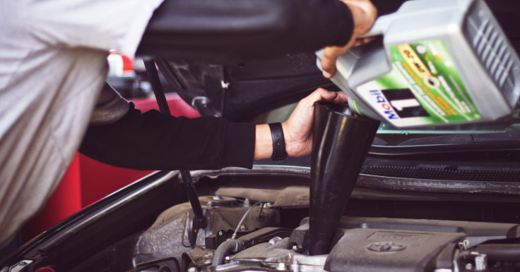 Guy Pouring Oil Into Vehicle