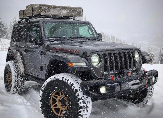 Jeep in snow with a roof top tent