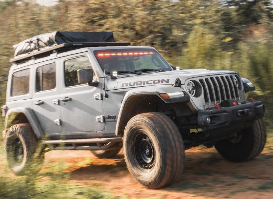 Sliver Jeep Wrangler with a roof top tent