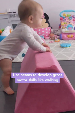 baby using a trapezoid foam piece to learn how to walk