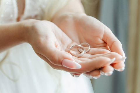 Just Gold Jewellery - the bride holds wedding rings in her palm wedding