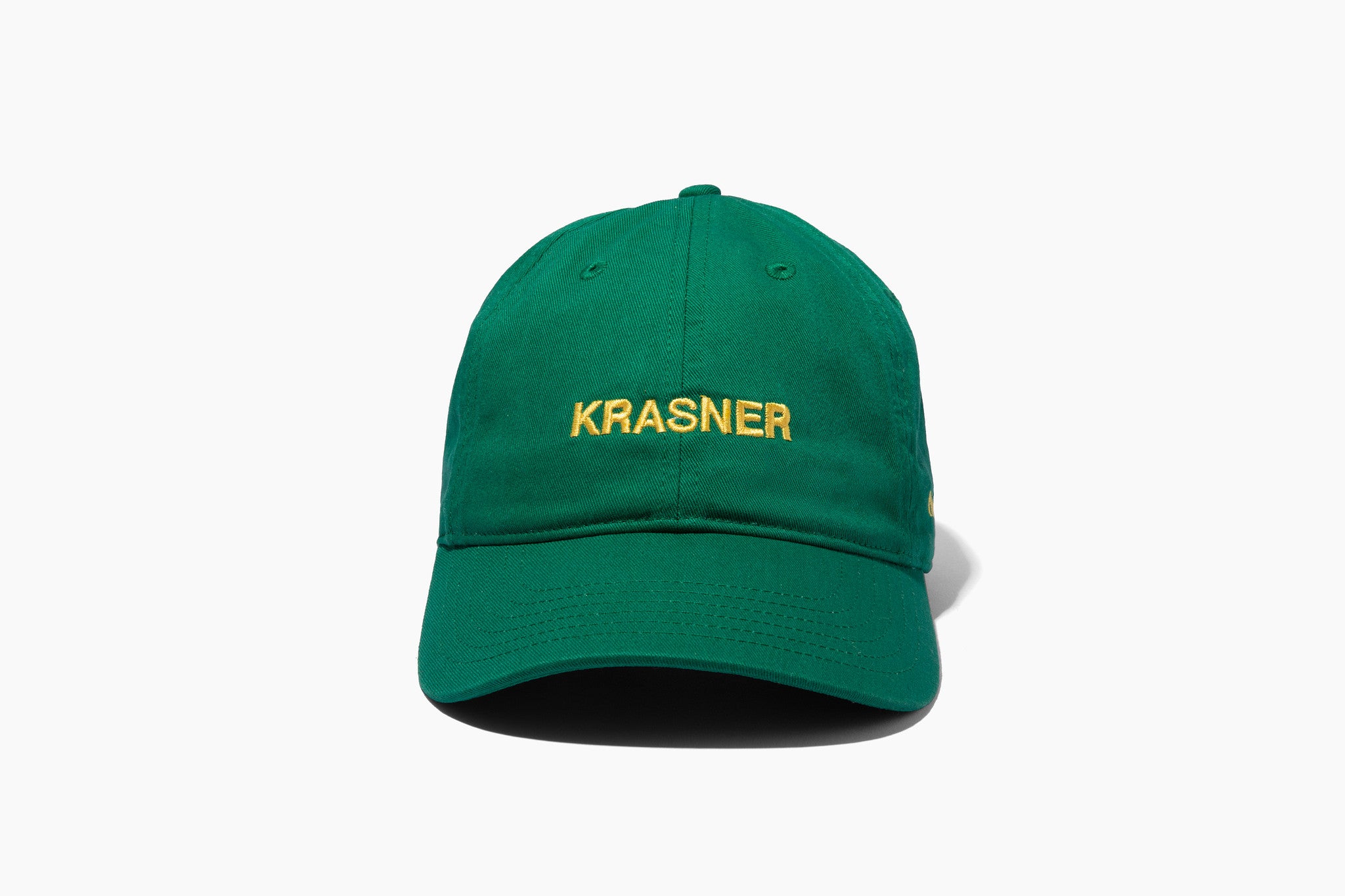 Green baseball cap with yellow embroidered "KRASNER" text on front, minimalist design, Cultured Magazine Hamptons issue exclusive hat.