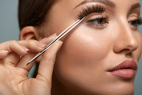Applying false lashes to eyelash extensions