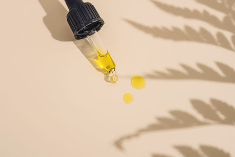 Face oil in dropper with a summer background