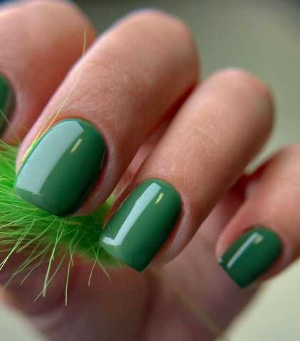 An image of nails with emerald green nail polish