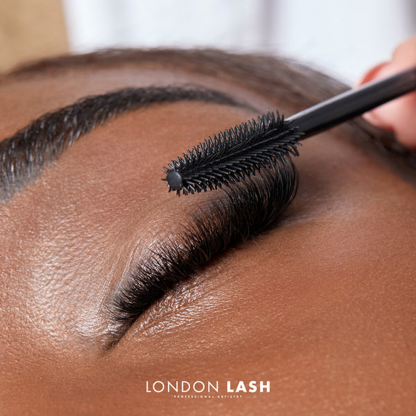Brushing eyelash extensions with a spoolie brush