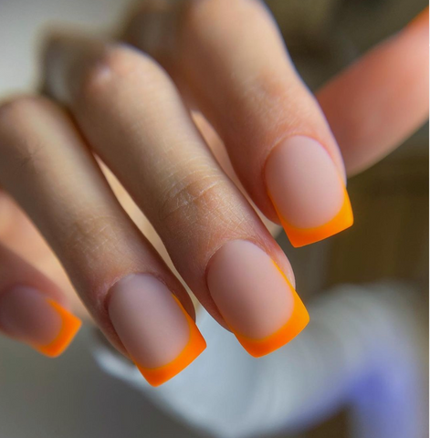 An image of french gel nails with orange nail polish and matte top coat