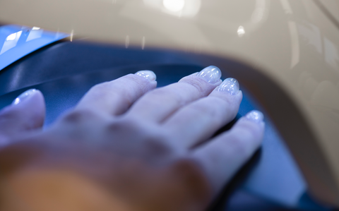 An image of gel nails curing under UV Light