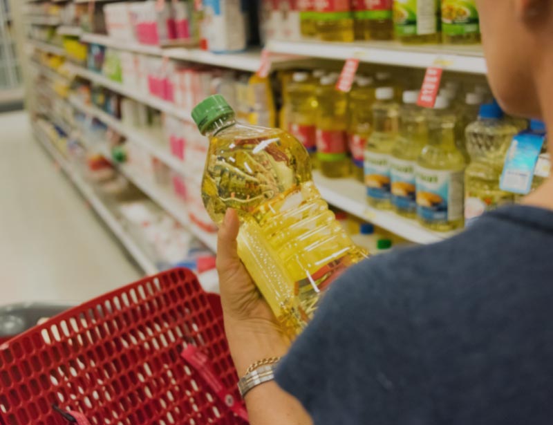 Person at a grocery store buying cooking oil