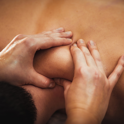 Muscular shoulder receiving massage with body oil