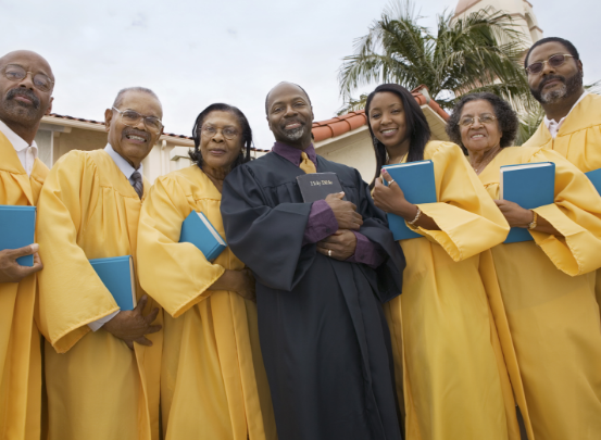 Choral group members, dressed in traditional church robes, posing for a photo