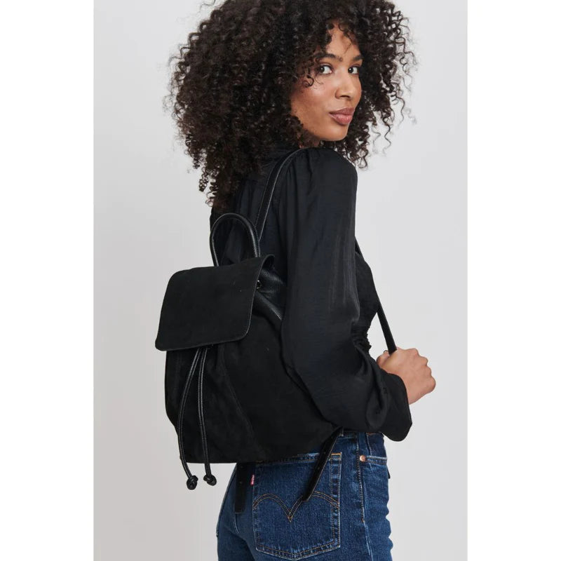 woman wearing a genuine leather backpack over one shoulder