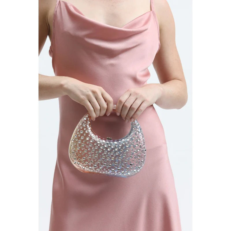 Woman in pink silk dress with a sparkly clutch purse