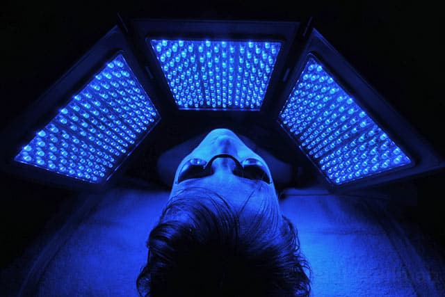 Séance de Photothérapie LED visage avec la lumière bleue traitant principalement l'acné