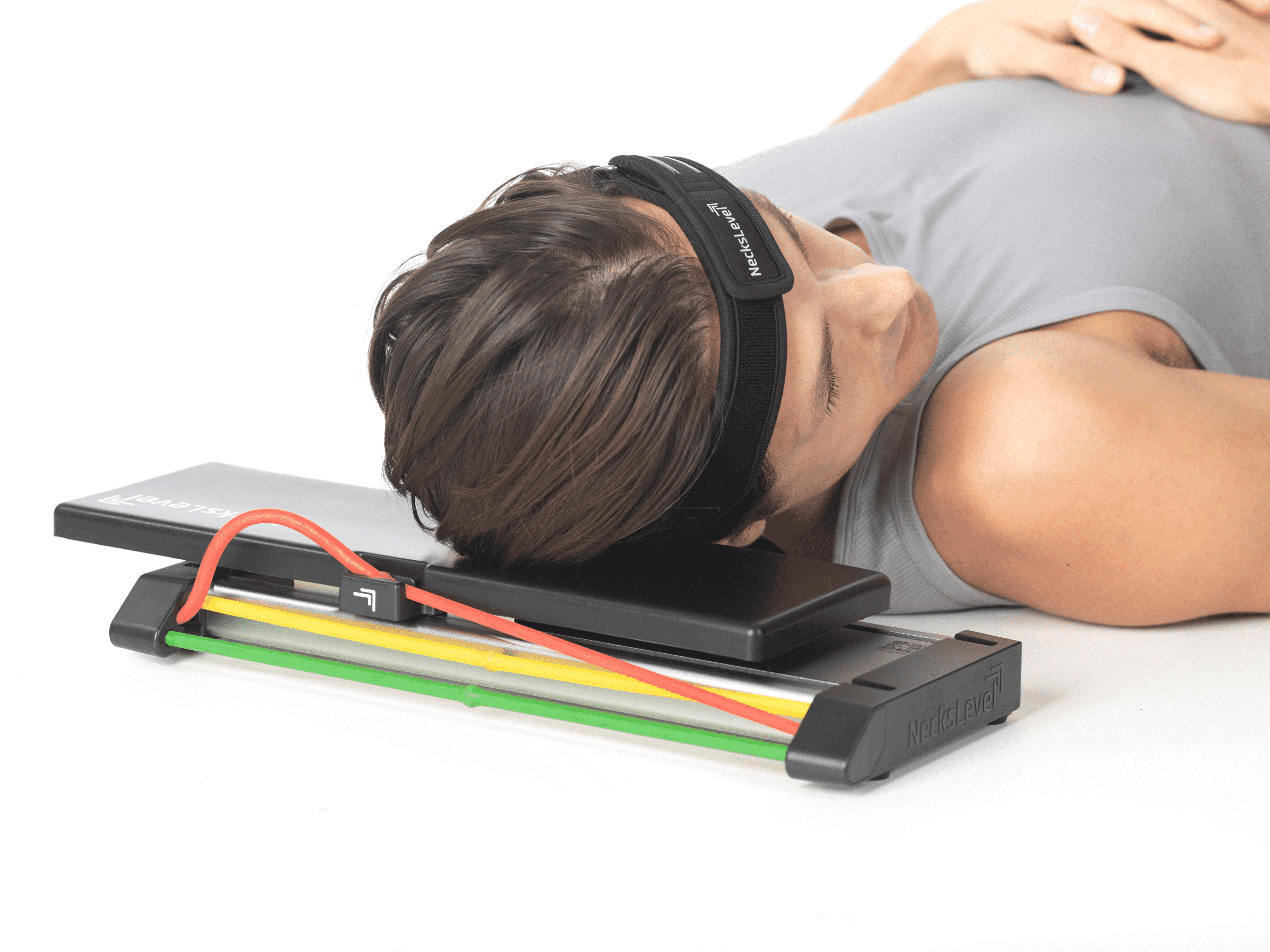 Person lying on back with head resting on exercise pad and resistance bands.