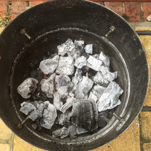 Spread the lit coals evenly in the bottom of the smoker