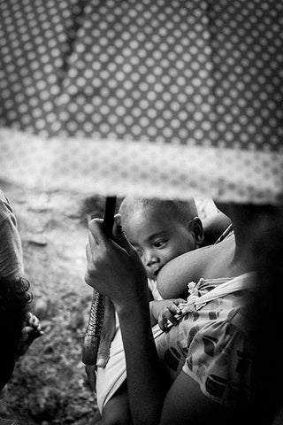 Femme africaine allaitant son enfant au sein.