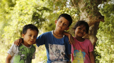 three kids wearing colorful blue, red and green graphic t-shirts