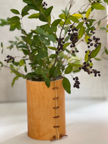 leather wrapped vase with a base of greens, privet