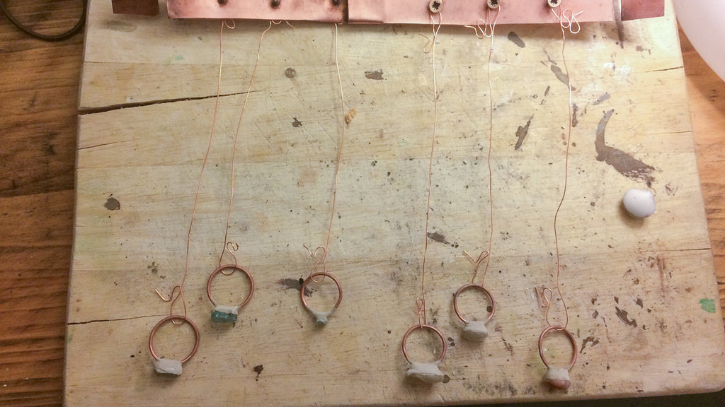 Rings hanging on copper S shaped hooks from copper bus bar
