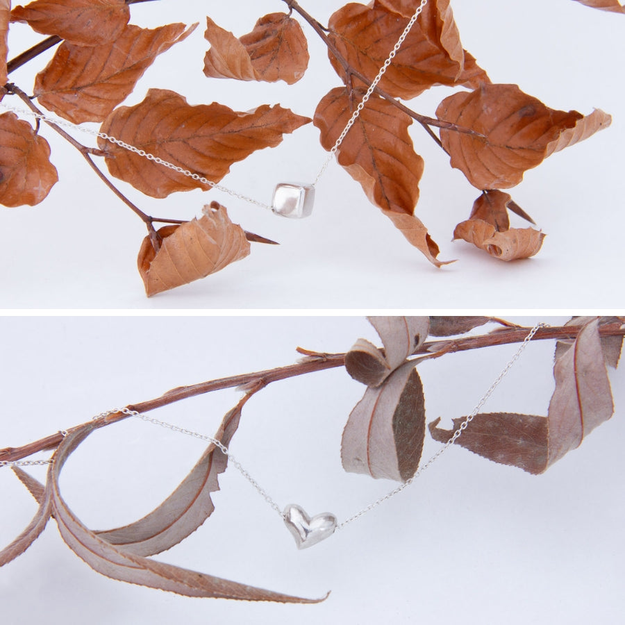 Carved with love pieces: cube at top, heart at bottom, both strung on branches of leaves collected from the riverside