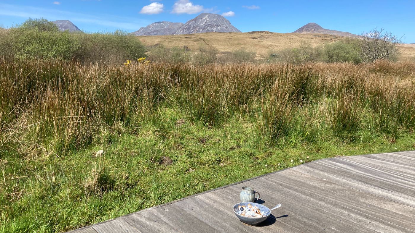 Slow-food - breakfast in front of the Paps in Jura; hand thrown coffee cup and cereal on sunshine filled decking