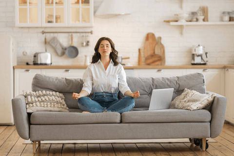Frau bei Meditation auf dem Sofa