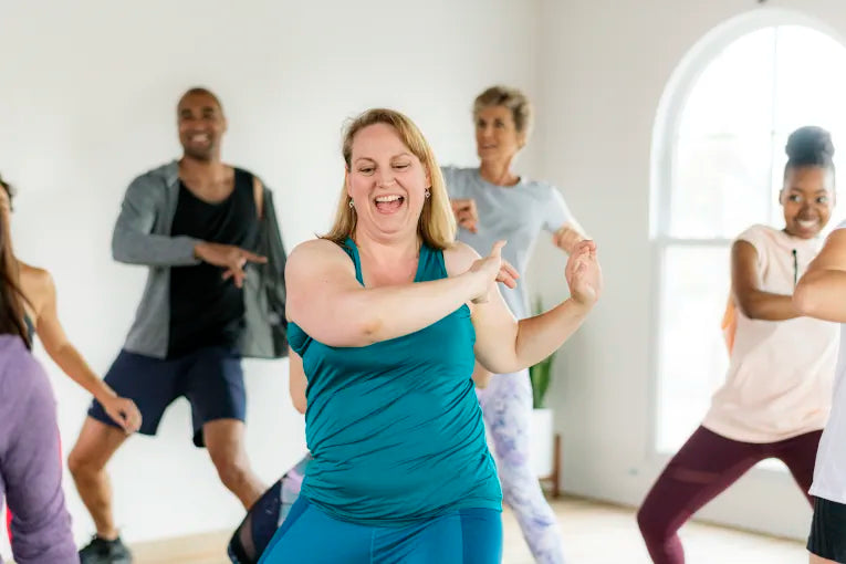 women in a fitness class dancing and having fun with other people