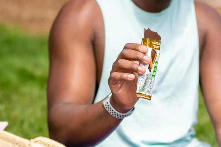 man eating No Sugar Company's no sugar keto nutritious bar 