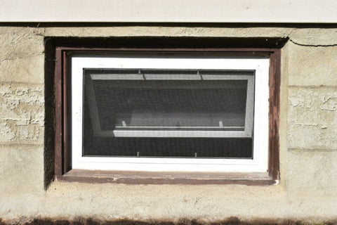 A photo of an egress window installed in a basement foundation.