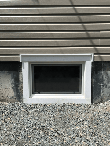 A photo of an egress window installed in a basement foundation.