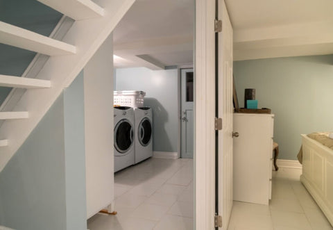 A photo of a finished basement with a bedroom and laundry room.