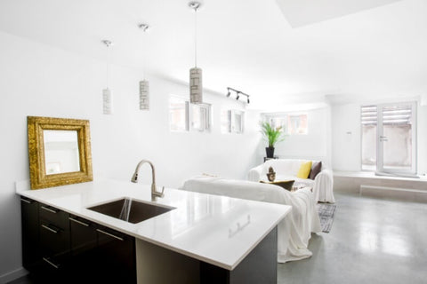 A photo of a finished walkout basement featuring a kitchen and living area with egress windows.