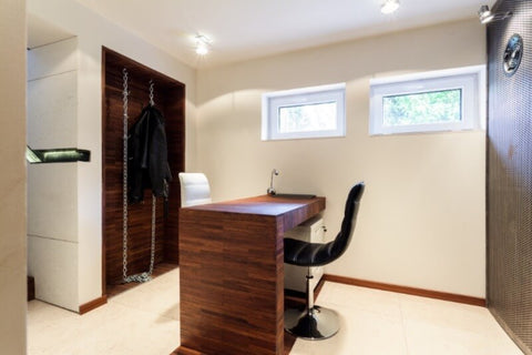A photo of a finished office in a basement with two egress windows.