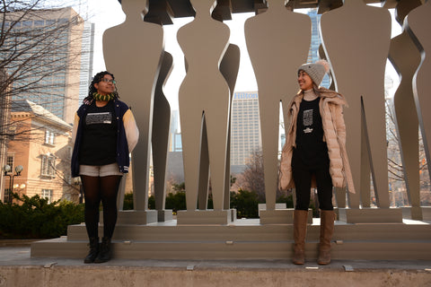 2 women wearing Lady Justice Apparel™  t-shirts at Pillars of Justice Sculpture Superior Court of Justice (361 University Avenue Courthouse) 