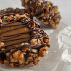 Up close shot of Trove Desserts handmade chocolate and caramel turtle cookie with pecans and chocolate drizzle
